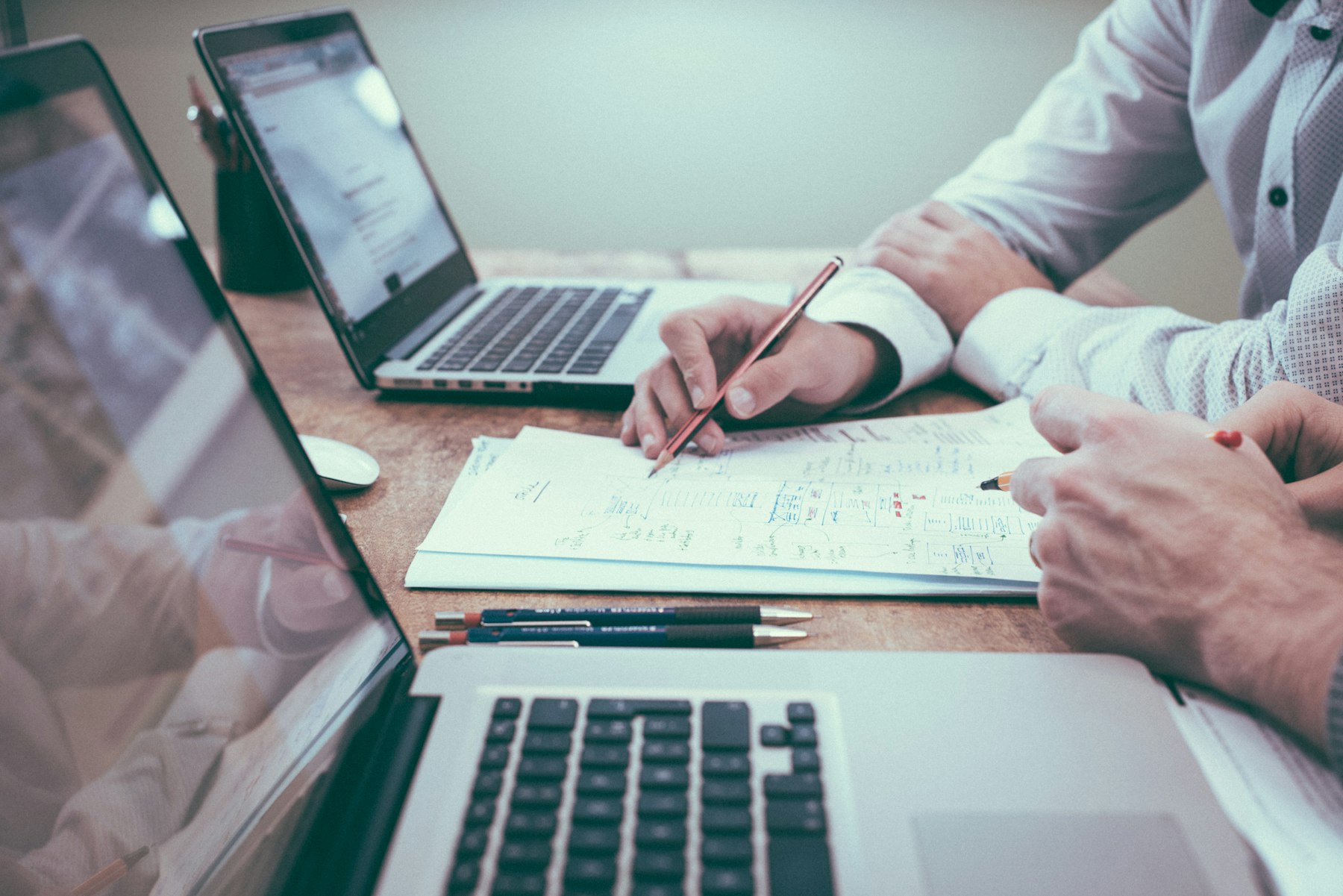 Business owners reviewing funding documents and a laptop at a conference table